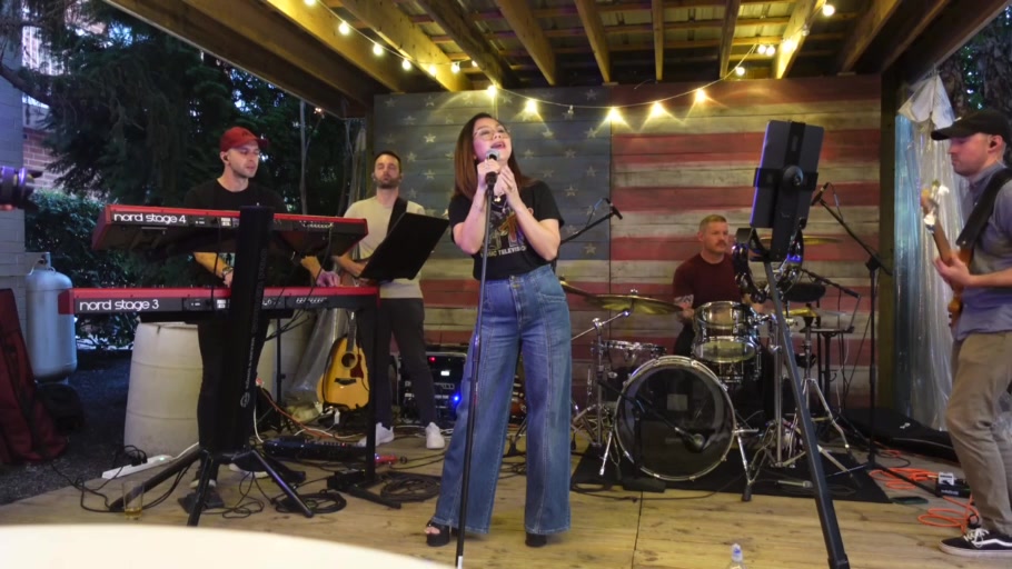 All five members of District Stereo performing together on stage
